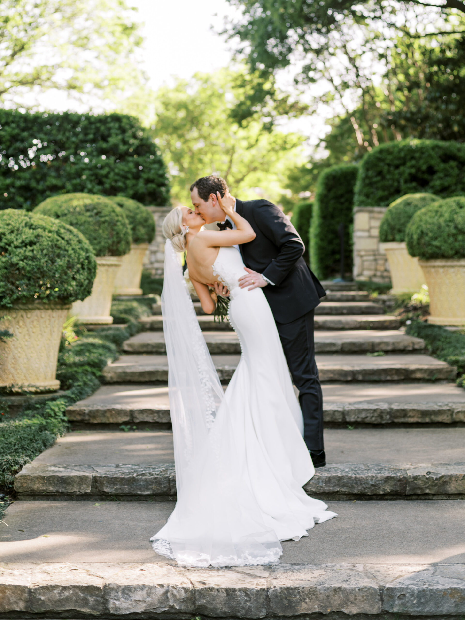 Bride & groom kiss romantically on the steps of The Sunken Gardens at The Dallas Arboretum, photographed by Dallas Wedding Photographer, Bethany Erin Photography.