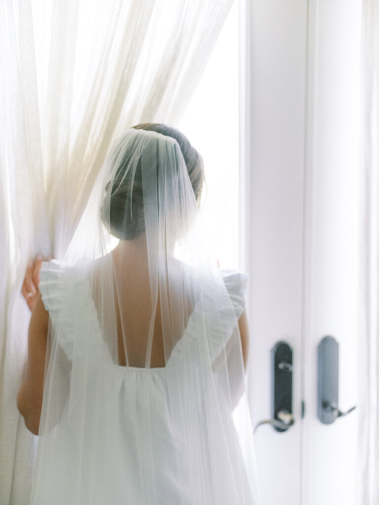 Bride looking out window photographed by Dallas Wedding Photographer, Bethany Erin Photography. 