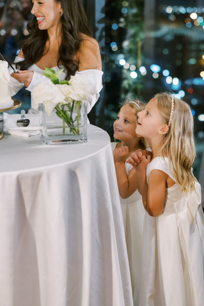 Flower girl's watching with anticipation during bride & groom surprise baby gender reveal wedding cake cutting at Hotel Swexan, photographed by Dallas Wedding Photographer, Bethany Erin Photography.