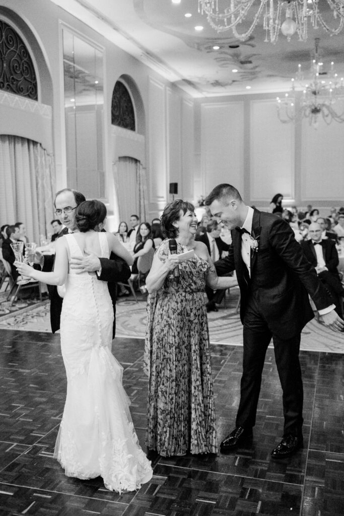Candid photograph with bride and groom and parents of the bride at The Adolphus Hotel, photographed by Dallas Wedding Photographer, Bethany Erin Photography.